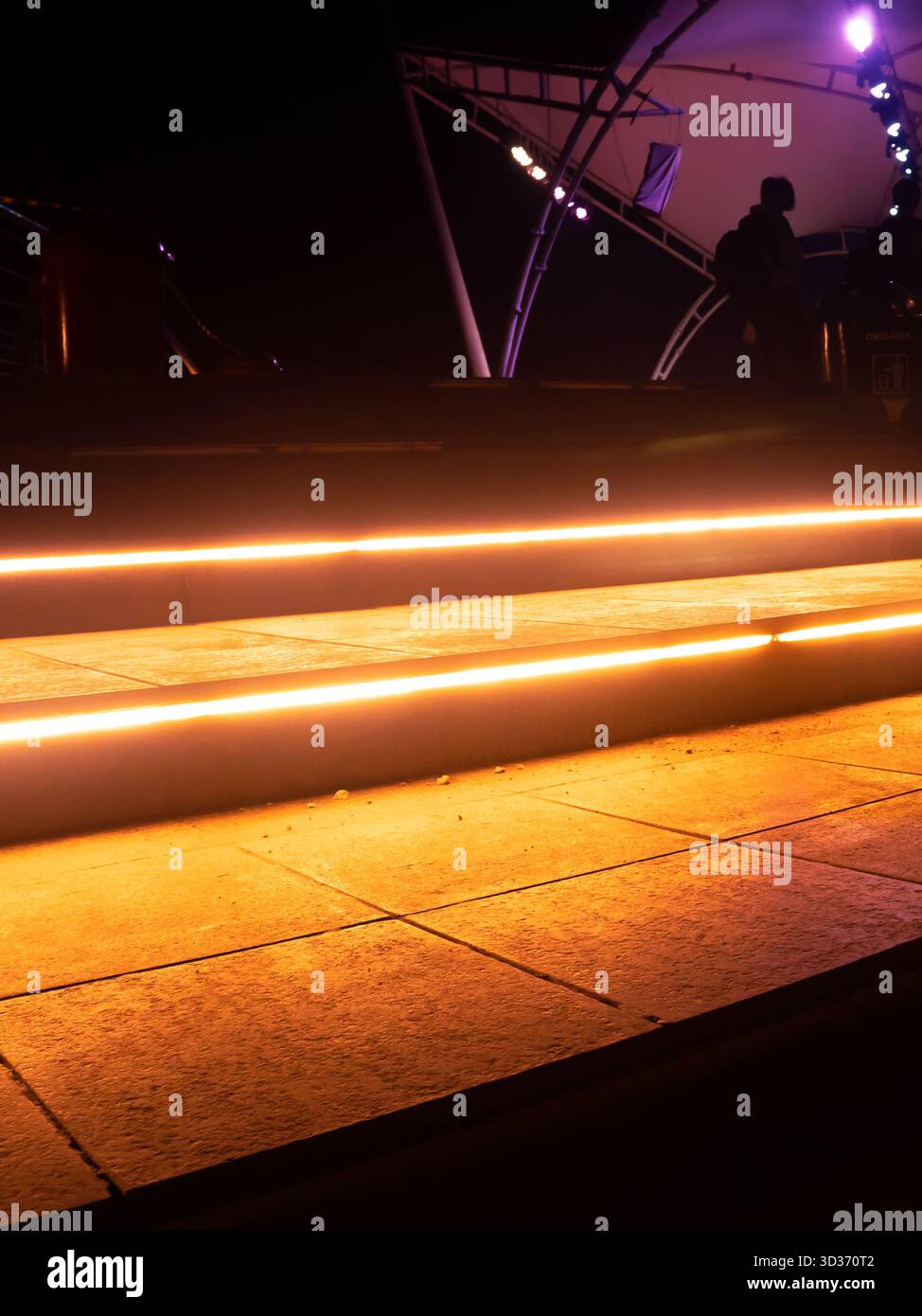 Gartentreppe bei Nacht mit gelben LED-Streifenlichtern Stockfoto