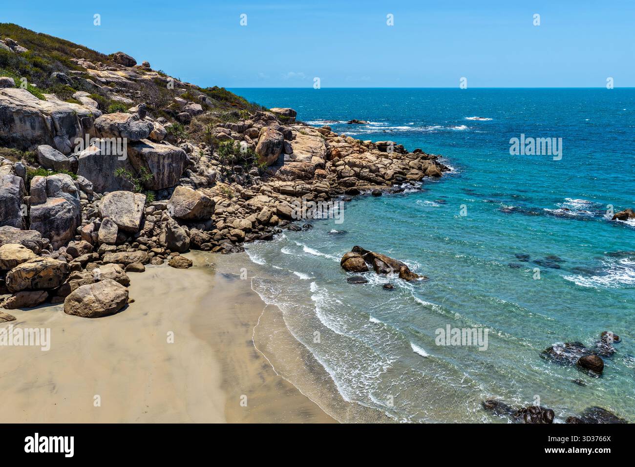 Ein Blick aus der Vogelperspektive auf die Rose Bay in Bowen, Queensland, zeigt eine atemberaubende tropische Küste mit türkisfarbenem Wasser, goldenem Sand und felsigen Landzungen. Stockfoto