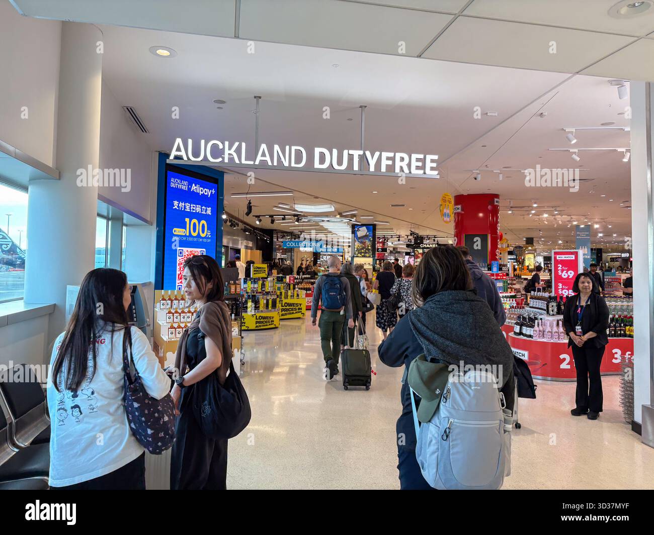 Auckland Dutyfree-Geschäft mit Reisenden, die eine große Auswahl an Produkten suchen, und eine Alipay-Aktion, die am Flughafen Auckland, Neuseeland, zu sehen ist. Stockfoto