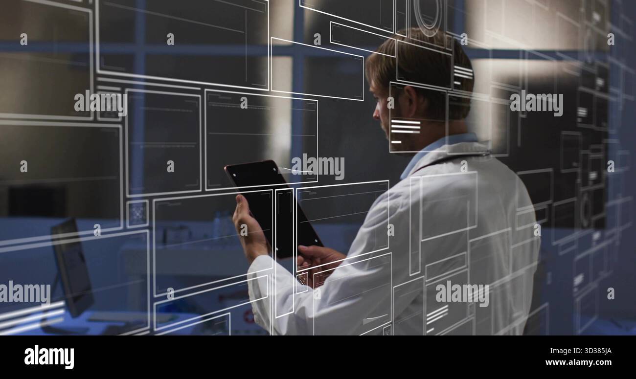 Technischer Laborkittel mit Tablettenüberzug im Kontrollraum, Laptop und Monitore Stockfoto