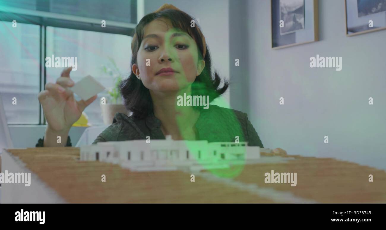 Asiatischer Designer mit Blazer, der Schaumstoffblock im Studio auf das Architekturmodell legt, mit Fenster Stockfoto