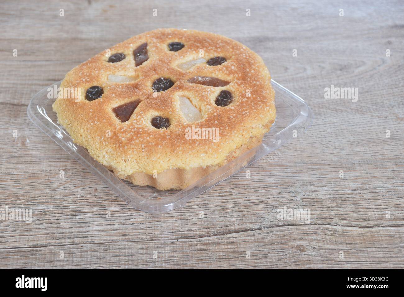 castella-Kuchen mit Rosinen und süßem Obst auf Plastiktablett Stockfoto