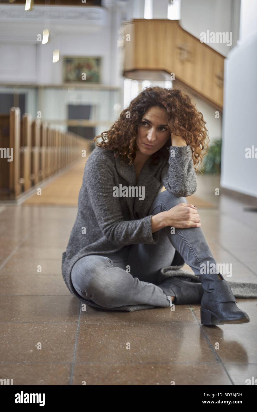 In der Kirche auf dem Boden zu sein, skeptisch, Religion, glaube, Sorgen, Problem, allein, Erschöpfung, religiös, innerlich, kirchliche, katholische, niedrige poi Stockfoto