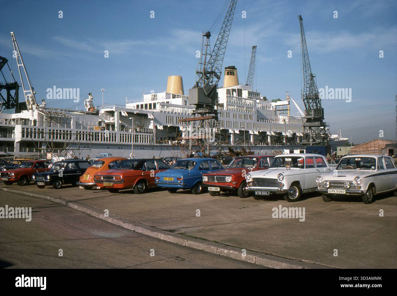 Hampshire, England. 1977: Ein Foto des Steuerbordfahrzeugs des P&O-Kreuzfahrtschiffes S. Oriana, das im Dry Dock No.7, Southampton Docks, gewartet wird. 28. Oktober 1977. Im Vordergrund steht eine Reihe von Autos, darunter ein Mazda 818, ein Singer Chamois, ein Volkswagen Beetle, ein Ford Granada Mk.1, ein Ford Escort Mk.1, ein Volvo 144, ein Morris Oxford Series V und ein Ford Cortina Mk.1. Stockfoto