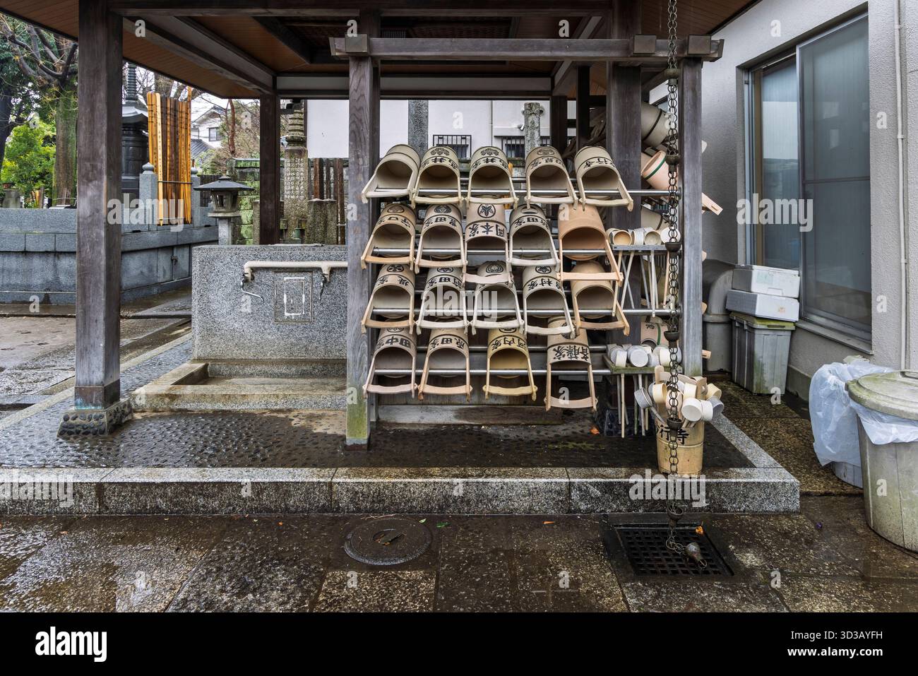 Waschkübel und Springbrunnen im Tempel im Yanaka Subsurb in Tokio, Japan. Yanaka ist ein stimmungsvoller, traditioneller Teil von Tokio, der für seine nostalgische Atmosphäre, Tempel und Katzen bekannt ist. Stockfoto