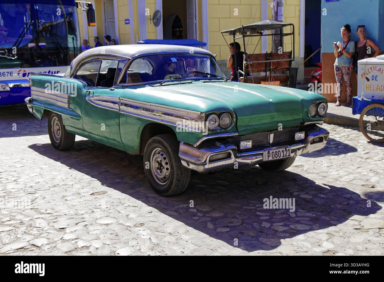 Trinidad, Kuba, Grosse Antillen, Karibik, Mittelamerika, Amerika, ein grüner Vintage-Wagen parkt auf einer sonnigen Kopfsteinpflasterstraße Stockfoto