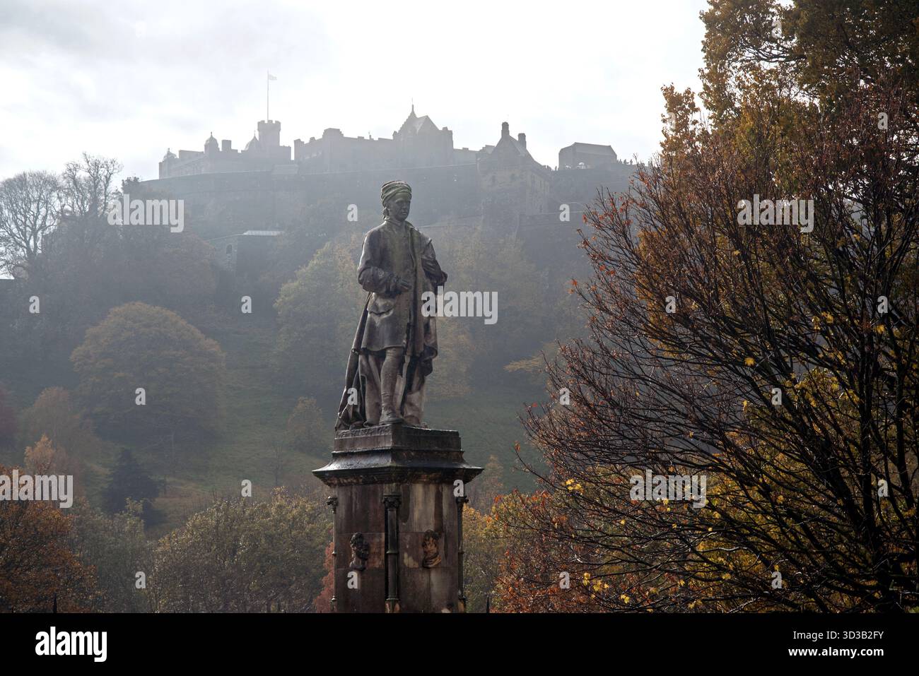 Allan Ramsay (1685–1758) staue von Sir John Steell in Princes Street Gardens an einem bewölkten grauen Herbsttag mit Edinburgh Castle im Hintergrund. Stockfoto