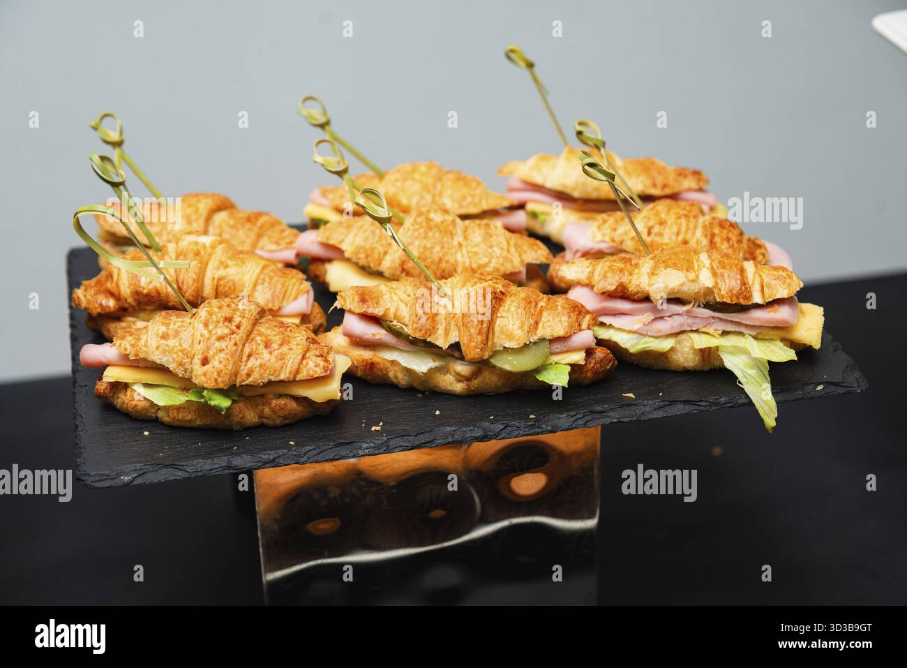 Essen, Tablett mit Mini Croissant Sandwiches gefüllt mit Schinken, Käse und Salat, ordentlich für ein Catering-Event oder Brunch arrangiert Stockfoto