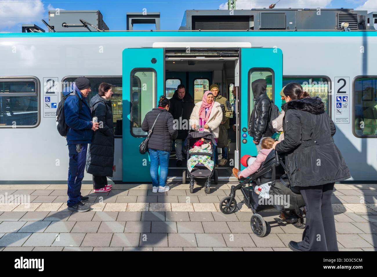 Passagiere mit Kinderwagen steigen am Dortmund Hauptbahnhof in einen S-Bahn-Zug ein. Stockfoto