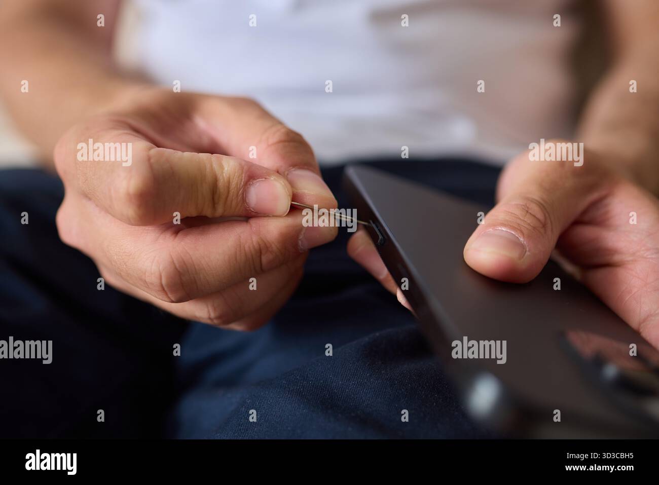 Anleitung zum ordnungsgemäßen Einsetzen einer SIM-Karte in ein Smartphone mit einem SIM-Entnahmewerkzeug Stockfoto