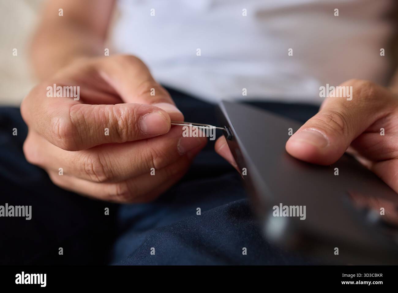 Anleitung zum ordnungsgemäßen Einsetzen einer SIM-Karte in ein Smartphone mit einem SIM-Entnahmewerkzeug Stockfoto