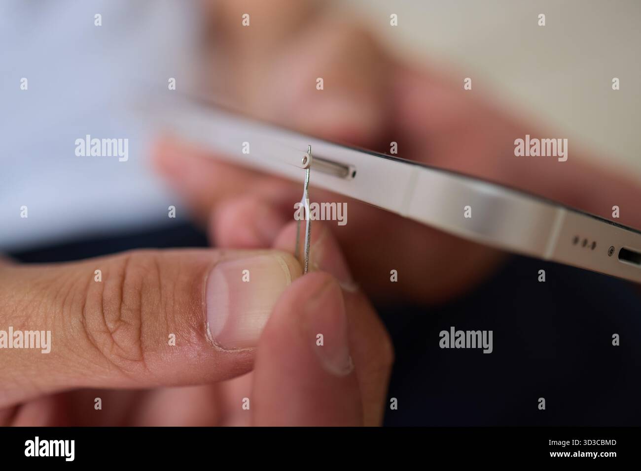 Anleitung zum ordnungsgemäßen Einsetzen einer SIM-Karte in ein Smartphone mit einem SIM-Entnahmewerkzeug Stockfoto