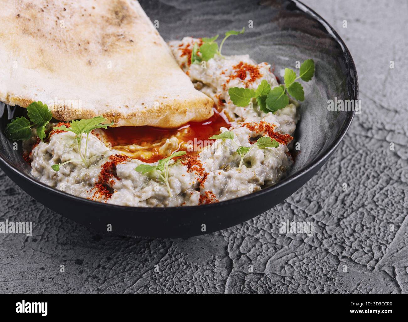 Essen, Auberginen-Kaviar mit Lavash auf schwarzer Schüssel Stockfoto