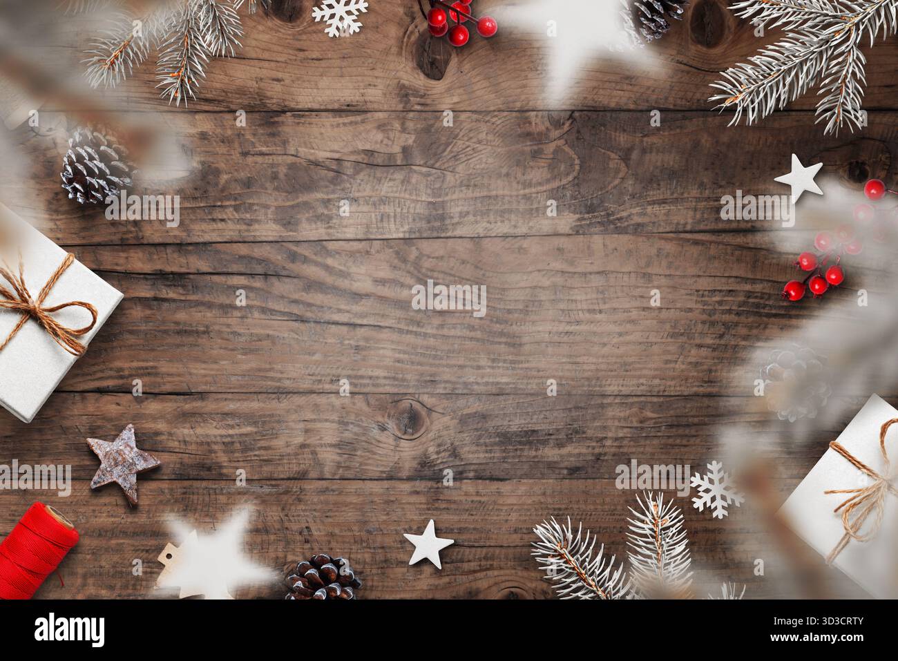 Festliche Weihnachtsflachlage mit frostigen Kiefernzweigen, Schneeflocken, Geschenken und roten Beeren auf hölzernem Hintergrund, Winterdekoration von oben Stockfoto