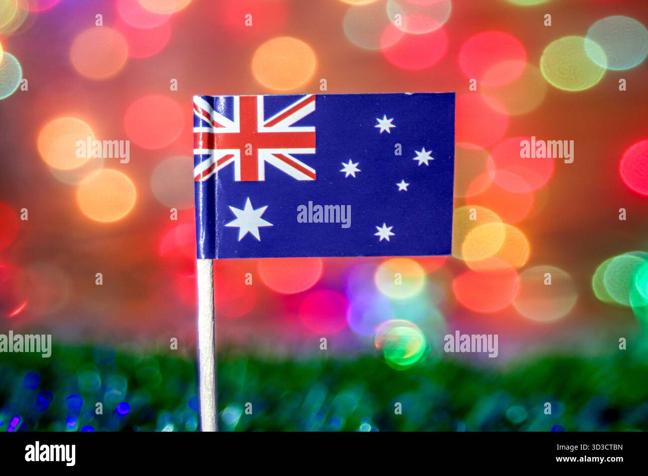 Nahaufnahme der australischen Flagge auf einem hellen, abstrakten Hintergrund mit verschwommenen Regenbogenlichtern. Symbolisiert Australien Day, Ozeanien und Nationalstolz. Stockfoto