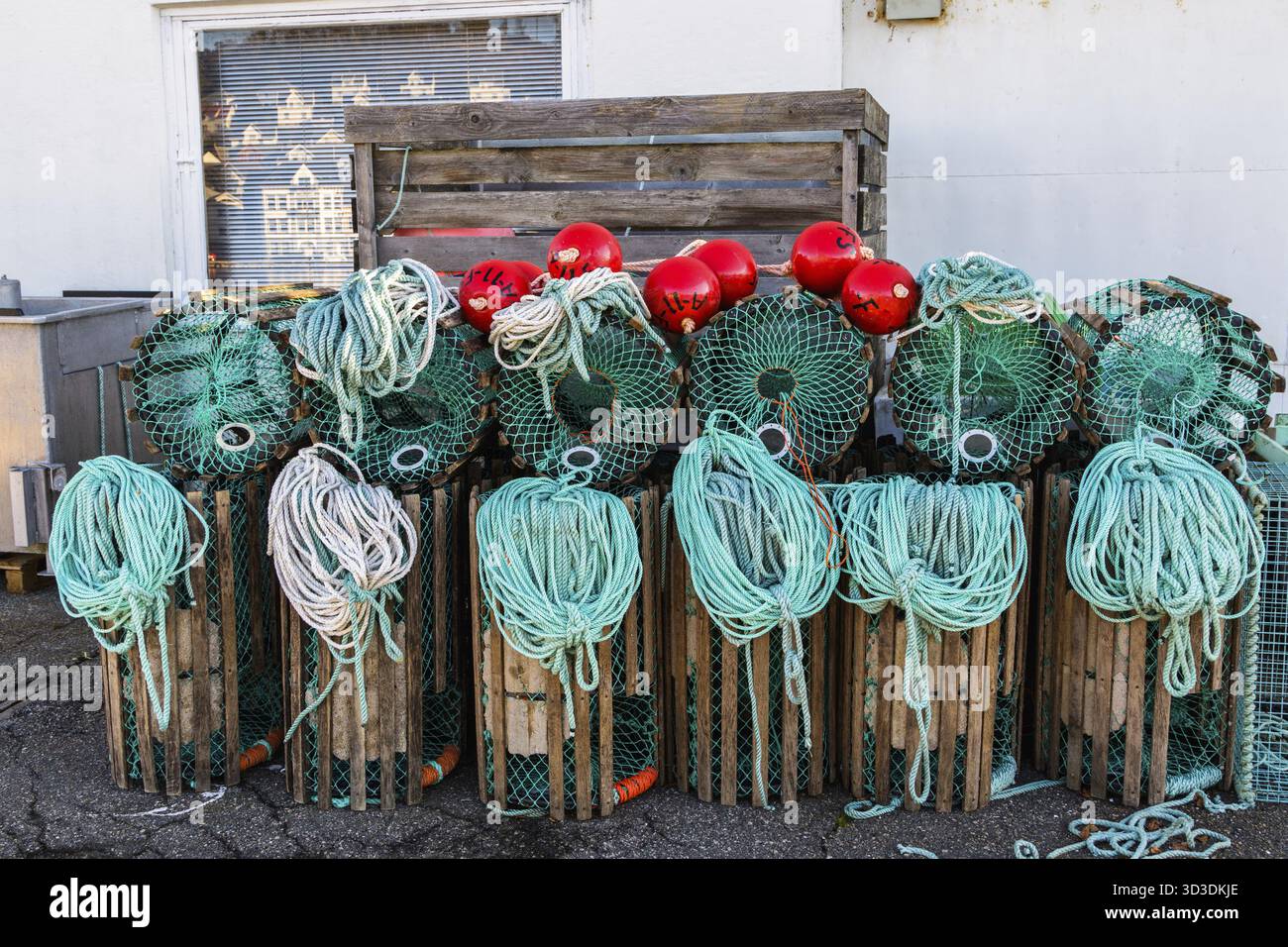 Hummerfallen stehen auf einem Pier, die zum Fischen mit Seilen und Bojen in einem norwegischen Fischerdorf vorbereitet sind Stockfoto