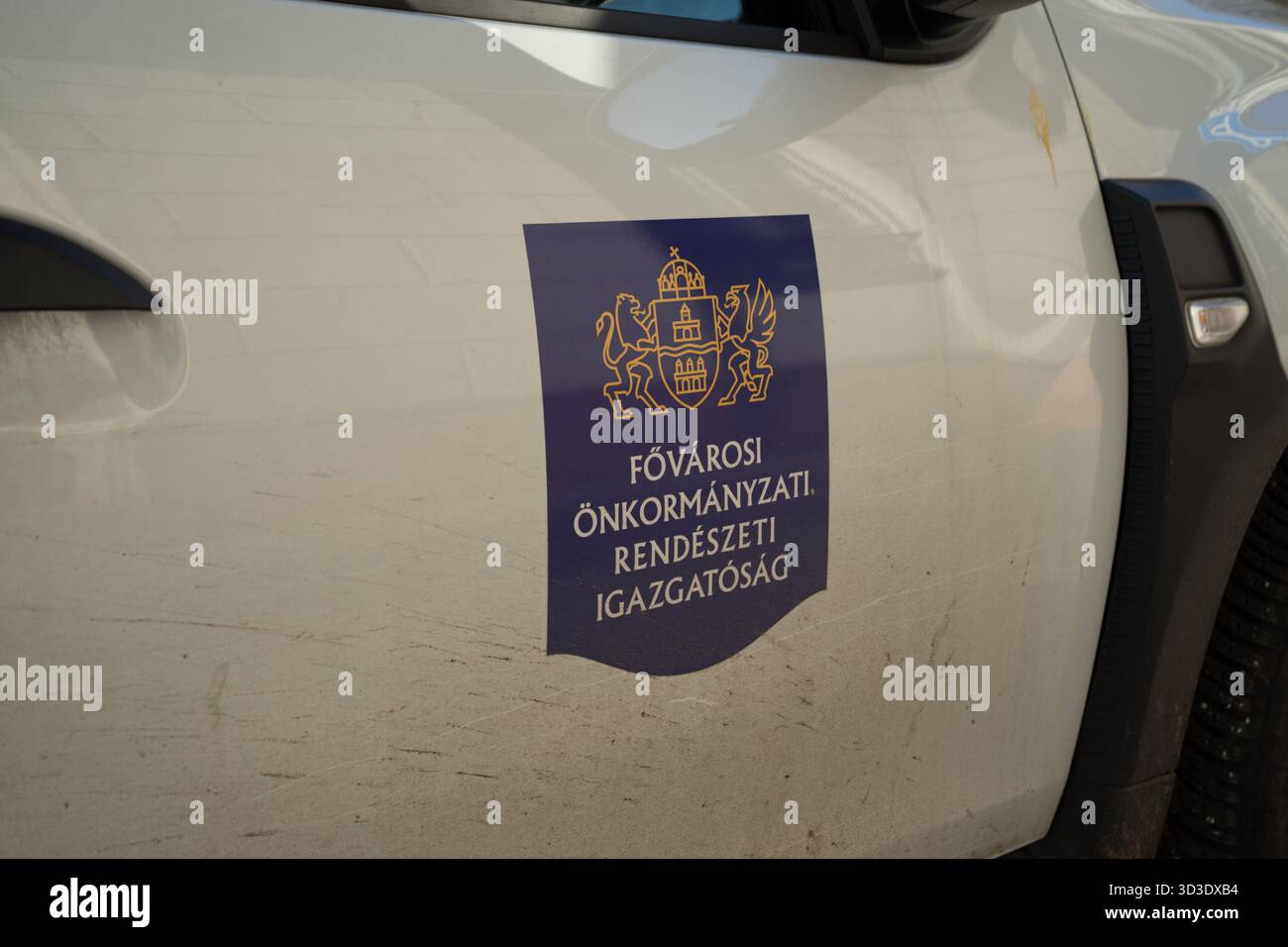 Abzeichen der Budapester gemeindedirektion für Strafverfolgungsbehörden an der Tür eines weißen Patrouillenwagens, eines offiziellen Stadtdurchsetzungswagens. Stockfoto