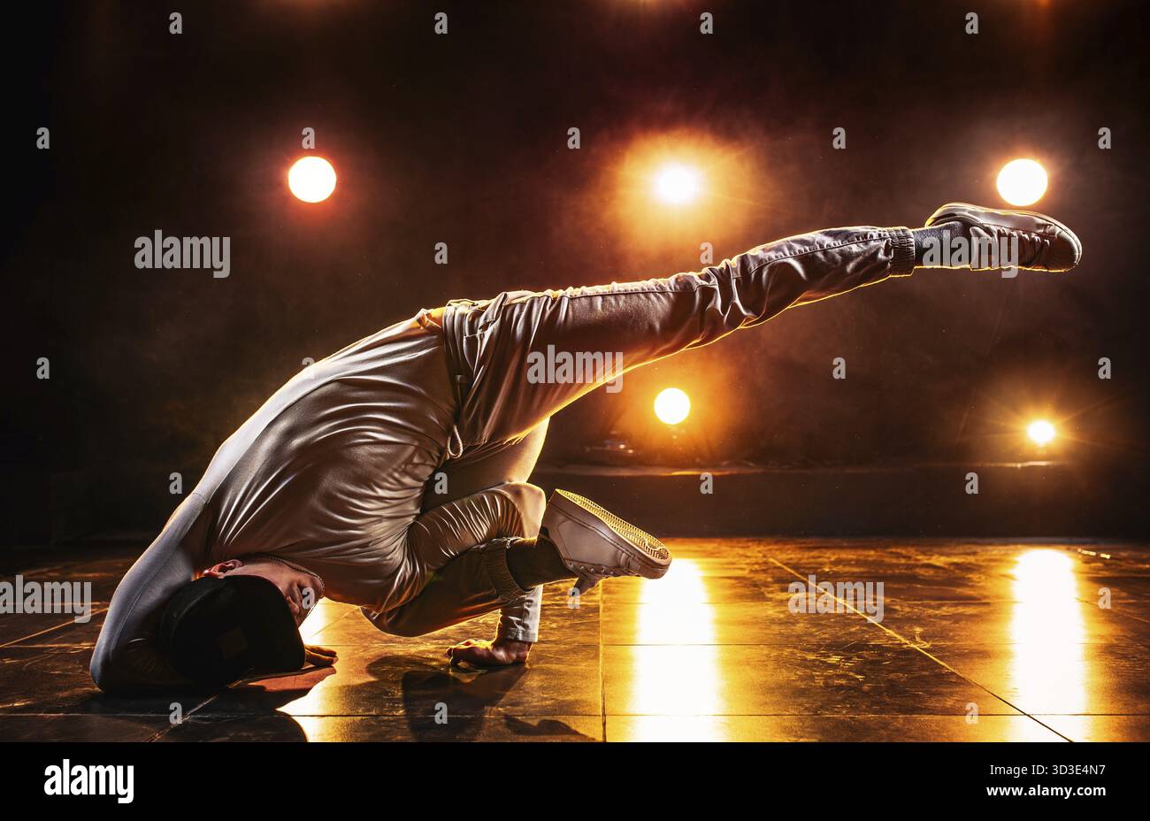 Junger Mann tanzt im Club mit roten Lichtern. Leuchtende Kontrastfarben Stockfoto