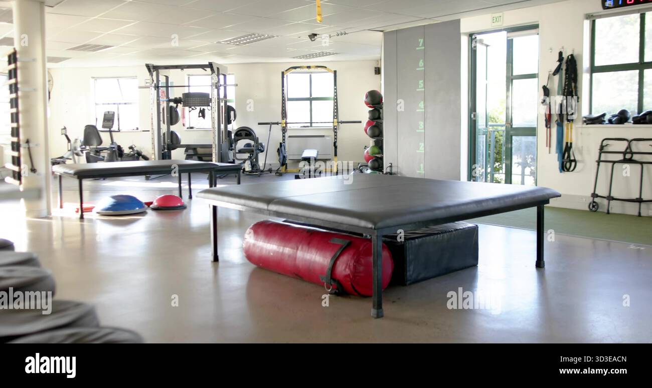 Dominante gepolsterte Plattform im Zentrum des Reha-Studios, mit roter Tasche und Schaumstoffblock darunter Stockfoto