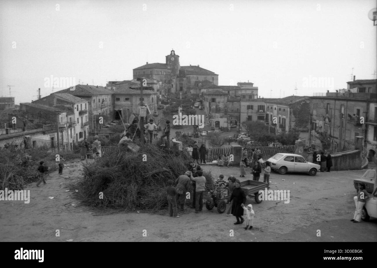 Roccagorga, Italien, 1982. Die Einheimischen bereiten mit vielen Kindern ein großes Lagerfeuer für ein traditionelles Ereignis namens Karfreitagsfeuer (Focaracci del Venerdì Santo) vor. Dieser Scheiterhaufen wurde vor der Kirche Santi Leonardo e Erasmo aufgestellt. Stockfoto