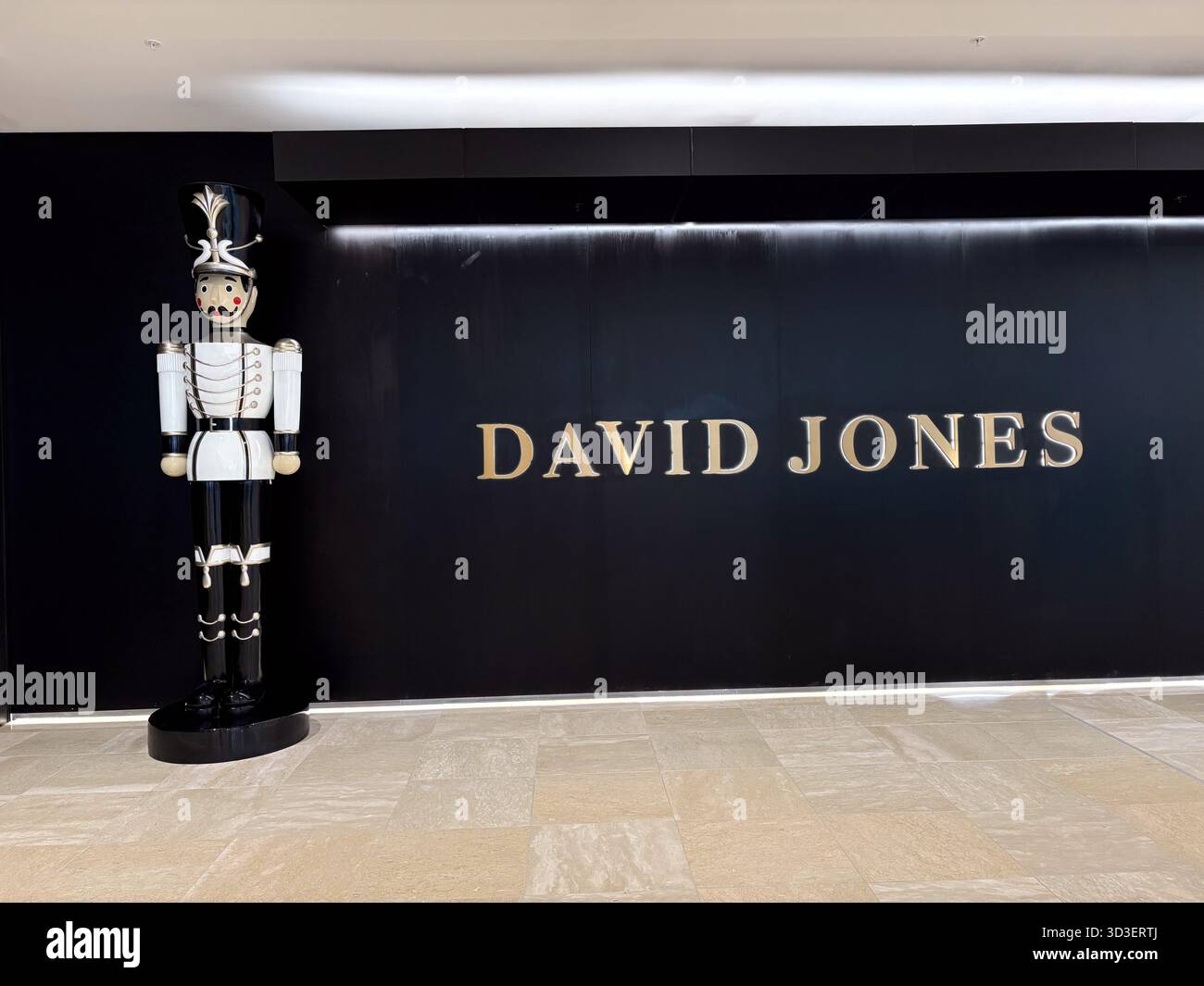 Eingang des Kaufhauses David Jones mit seinem goldenen Logo an einer schwarzen Wand und einem großen Nussknacker-Dekor in Chatswood, Sydney, Australien. Stockfoto