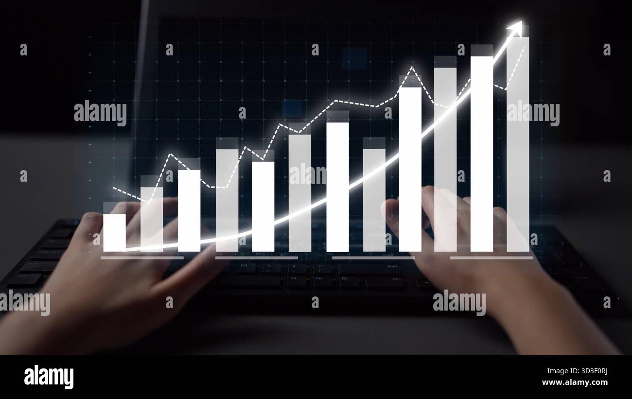 Dieses Bild zeigt ein Paar Hände, die auf einer Tastatur tippen. Auf dem Bildschirm wird ein dynamisches Geschäftsdiagramm angezeigt, das Wachstum und datengesteuerte Daten symbolisiert Stockfoto