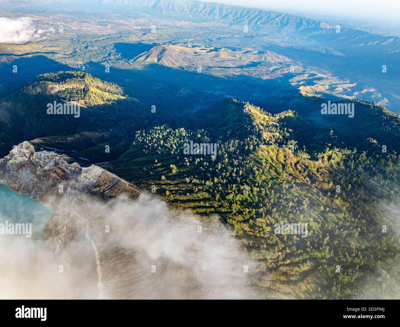 Aus der Vogelperspektive auf die Felsenklippe am Kawah Ijen Vulkan mit türkisfarbenem Schwefelwassersee bei Sonnenaufgang. Fantastischer Blick auf die Naturlandschaft in Ost-Java, Indonesien. Natu Stockfoto