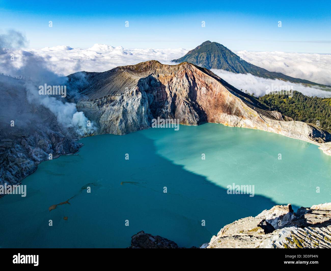 Aus der Vogelperspektive auf die Felsenklippe am Kawah Ijen Vulkan mit türkisfarbenem Schwefelwassersee bei Sonnenaufgang. Fantastischer Blick auf die Naturlandschaft in Ost-Java, Indonesien. Natu Stockfoto
