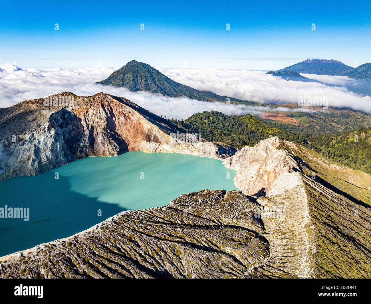 Aus der Vogelperspektive auf die Felsenklippe am Kawah Ijen Vulkan mit türkisfarbenem Schwefelwassersee bei Sonnenaufgang. Fantastischer Blick auf die Naturlandschaft in Ost-Java, Indonesien. Natu Stockfoto