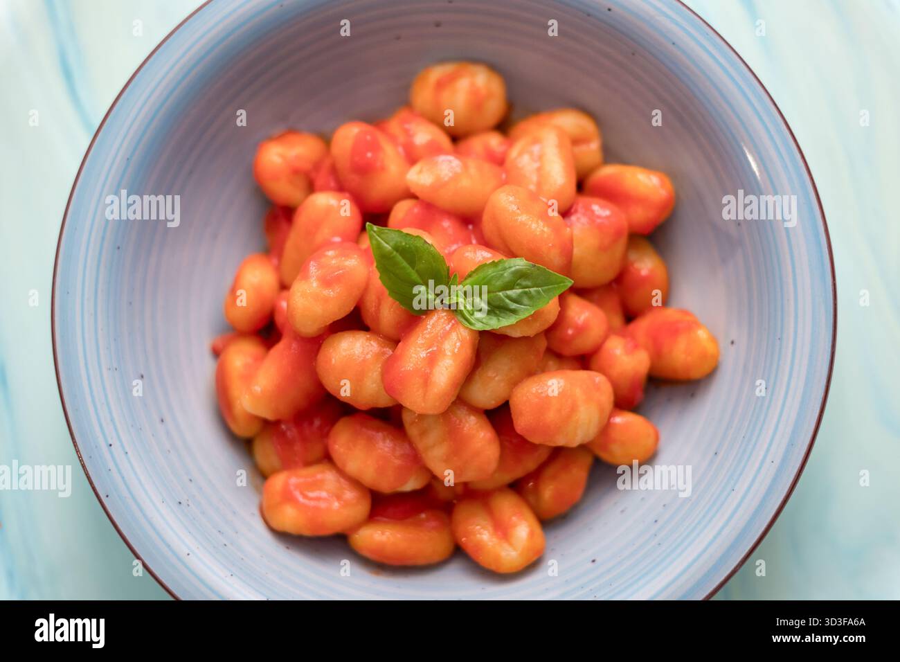 Kartoffelgnocchi mit reichhaltiger Tomatensauce und frischem Basilikum Stockfoto
