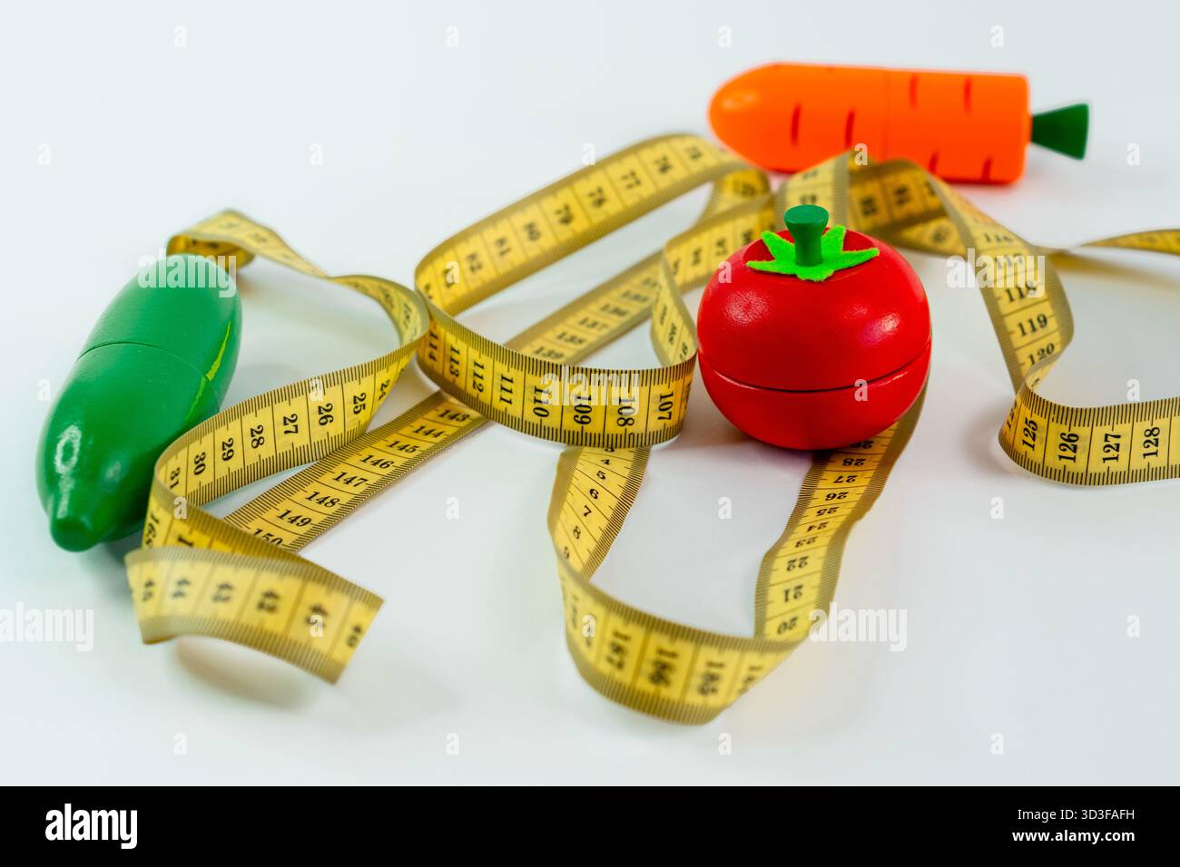 Flachlage mit Maßband und Spielzeuggemüse, das Konzept von Ernährungsrezepten und Gewichtsverlust Stockfoto