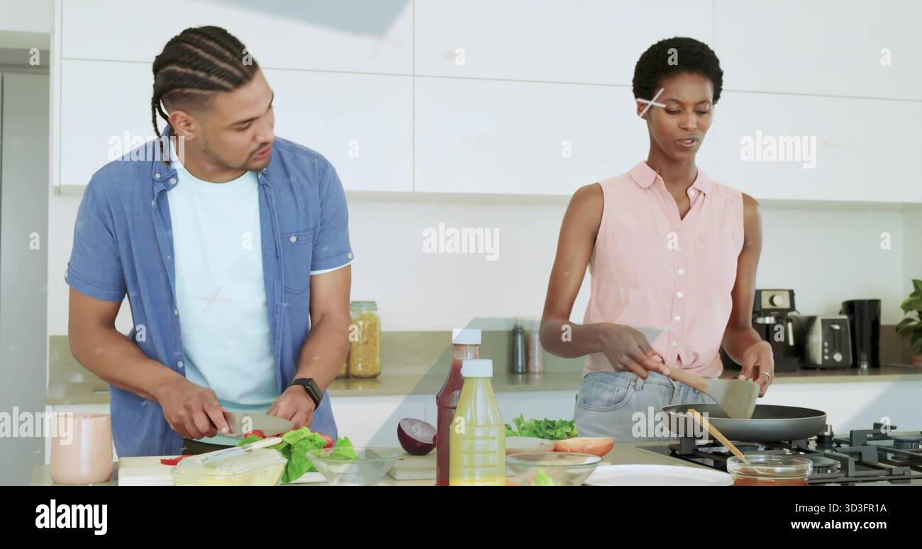 Gemüse schneiden, während Lebensmittel gerührt werden Paar in der modernen Küche, mit Schneidebrett und Bratpfanne Stockfoto