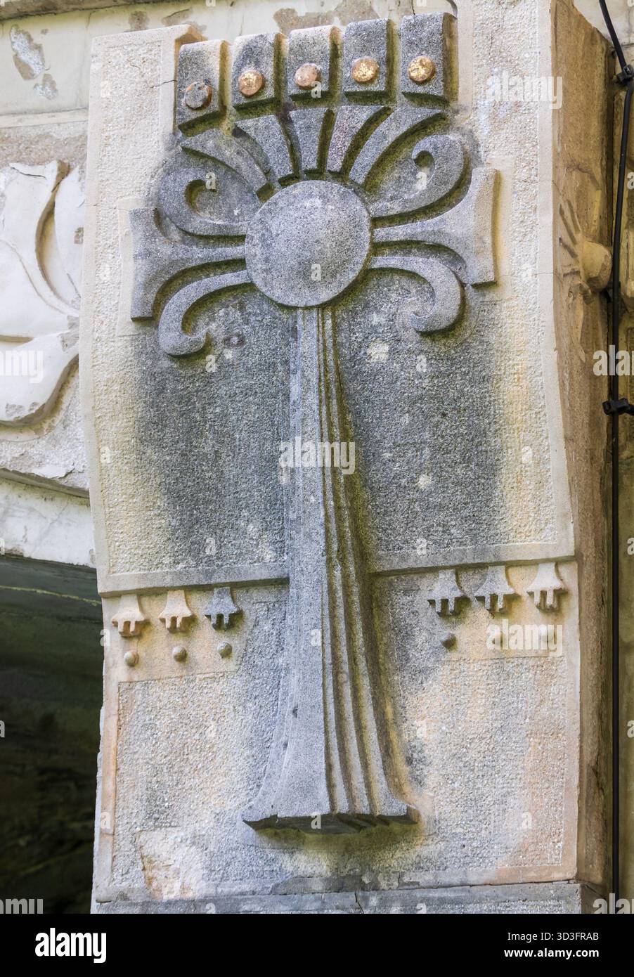 Steinrelief mit stilisiertem Blumenmotiv auf architektonischen Details Stockfoto