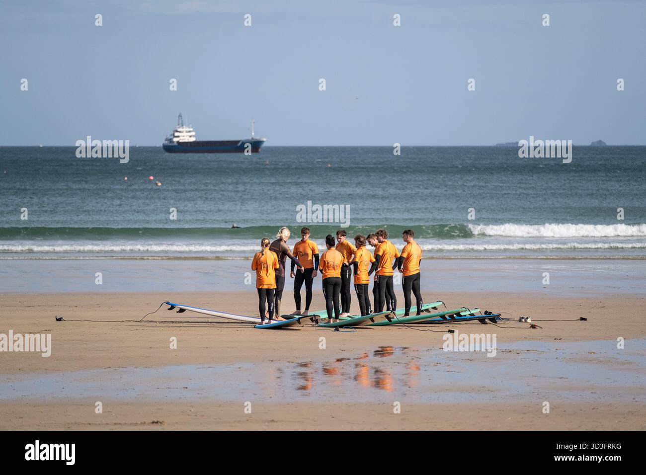 Eine Gruppe von Urlaubern, die an einer Surfstunde mit einem Lehrer der Cornish Wave Surf School am Towan Beach in Newquay in Cornwall in England teilnehmen Stockfoto