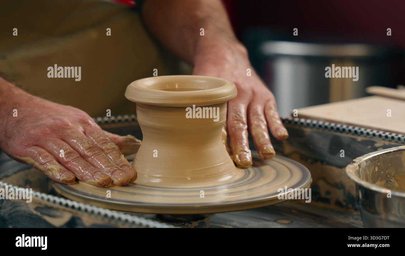 Unbekannter kaukasischer Mann Typ kleiner Geschäftsinhaber Handwerker Geschäftsmann männliche Hände Palmenfinger Formen Keramik Ton Schlamm machen Vase Topf auf Spinnen Stockfoto