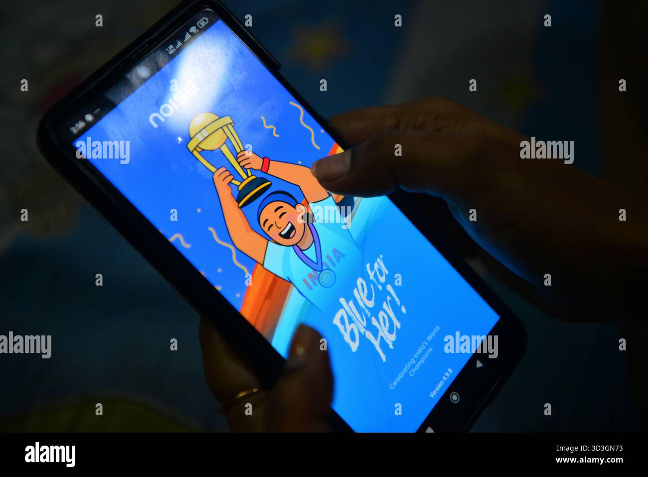 Siliguri, Westbengalen, Indien. November 2025. Eine Indianerin hält ihr Handy, während sie ihre tragbare Anwendung für Smart Watch synchronisiert und aktualisiert, die auch mit ihrem Handy gekoppelt ist. Sie zeigt das spezielle App-Symbol für Noise Fit Smart Watch, um den Weltmeisterschaftssieg des indischen Women's Cricket Teams in Siliguri zu feiern. (Kreditbild: © Diptendu Dutta/ZUMA Press Wire) NUR REDAKTIONELLE VERWENDUNG! Nicht für kommerzielle ZWECKE! Stockfoto