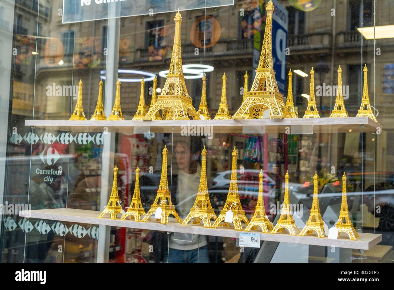 Paris, Frankreich - 30. Oktober 2025: Eiffelturm Modelle zum Verkauf Souvenir Figuren Set. Geschenke in goldener Farbe in der Schaufensterstraße Stockfoto