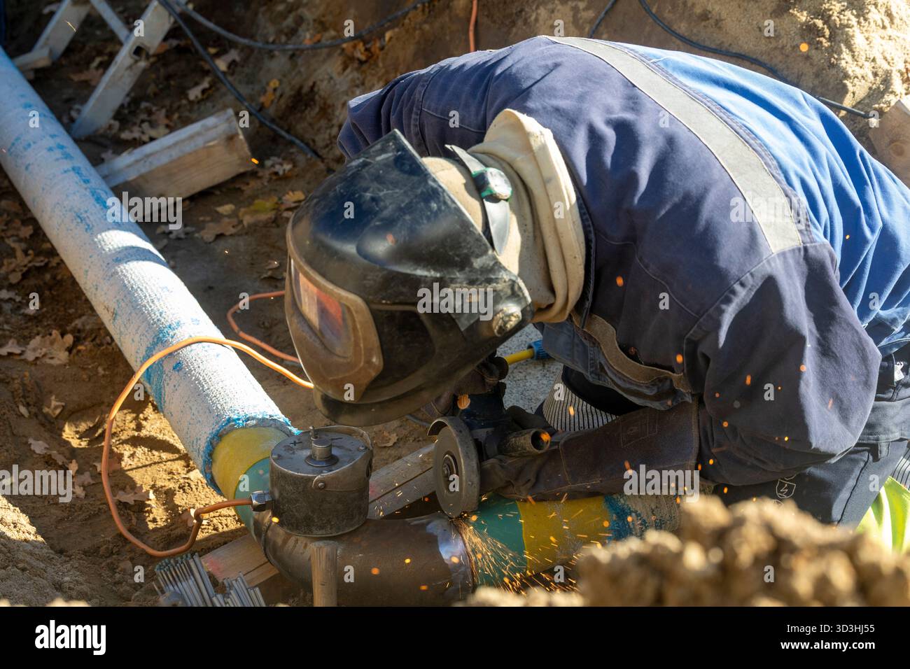 06. November 2025, Sachsen, Schönfeld: Ein Arbeiter arbeitet mit einem Winkelschleifer (FLEX) an einer Gasleitung nahe der Gemeinde Schönfeld im Landkreis Meißen. Foto: Daniel Wagner/dpa Stockfoto