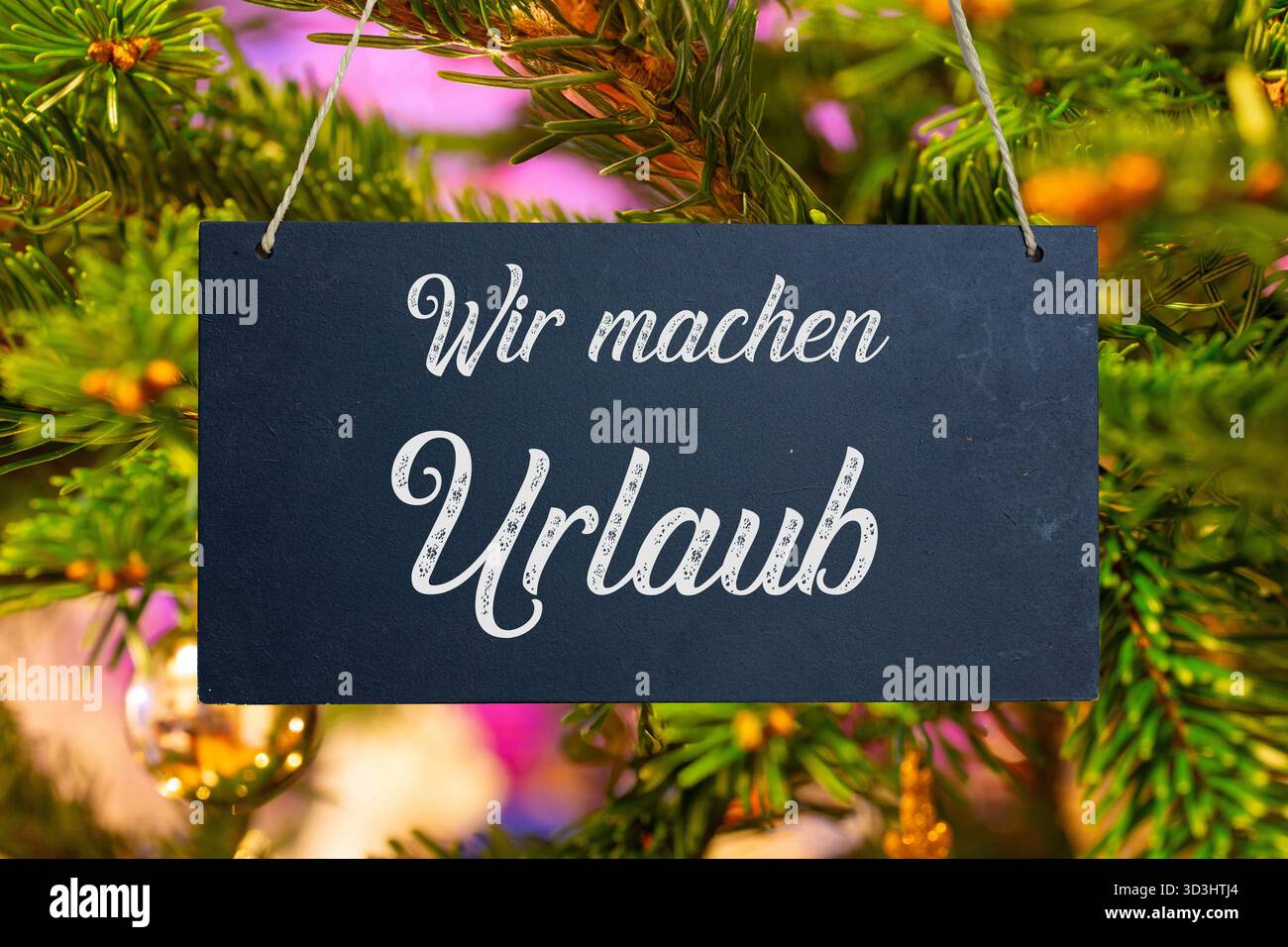 (Fotomontage) Firmenfeiertage zu Weihnachten: Schild mit der Aufschrift wir MACHEN URLAUB vor einem Weihnachtsbaum Stockfoto