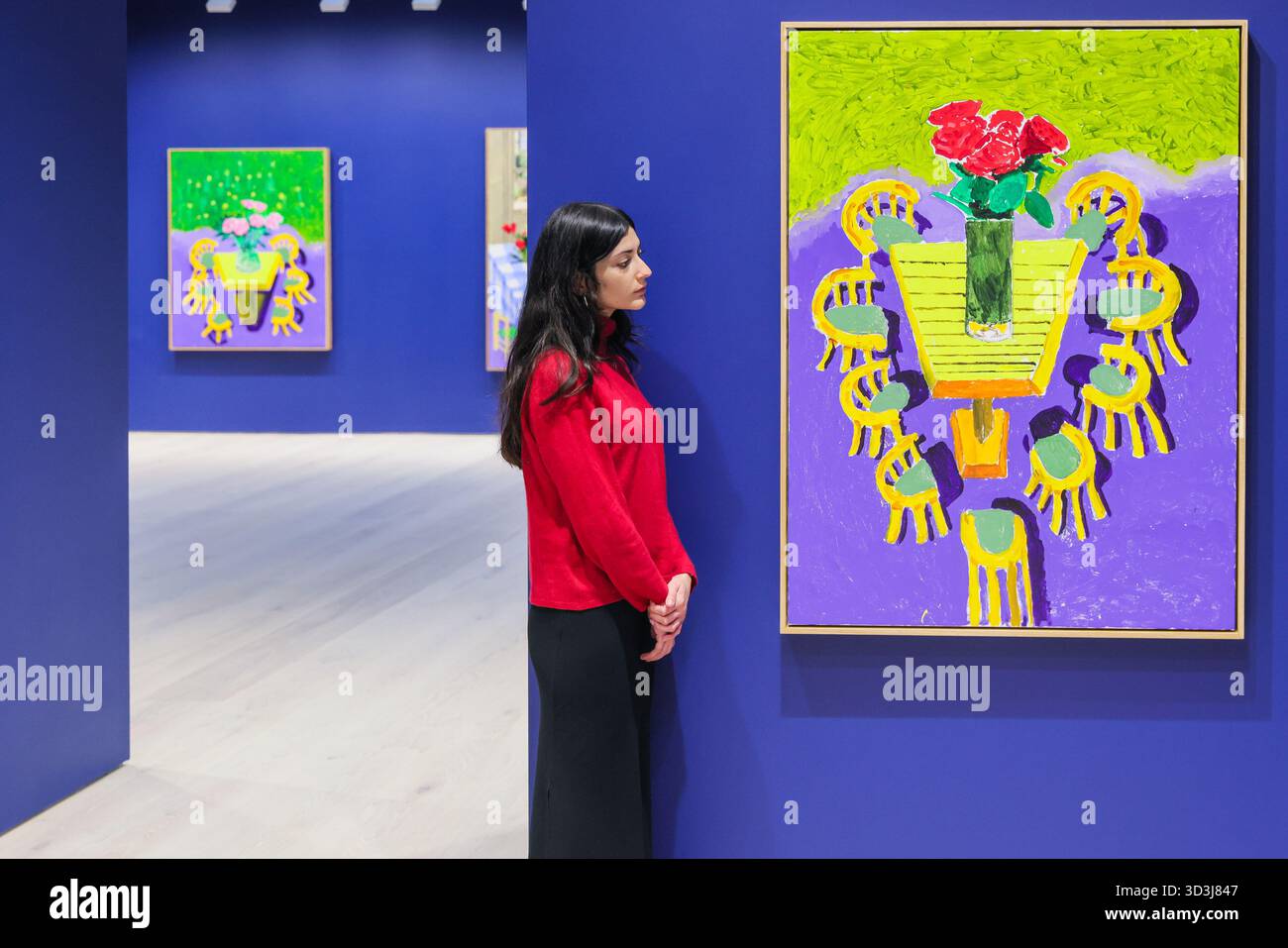 London, Großbritannien. November 2025. Mitarbeiter mit Red Roses on Show, August 2025, und andere Arbeiten im Raum dahinter. 'Einige sehr, sehr, sehr neue Gemälde, die noch nicht in Paris gezeigt wurden' Debüts, die nie zuvor in David Hockneys Londoner Atelier in den letzten sechs Monaten fertiggestellt wurden. Die Ausstellung ist die Eröffnungsausstellung im neuen Raum von Annely Juda Fine Art auf dem Hannover Platz. Quelle: Imageplotter/Alamy Live News Stockfoto