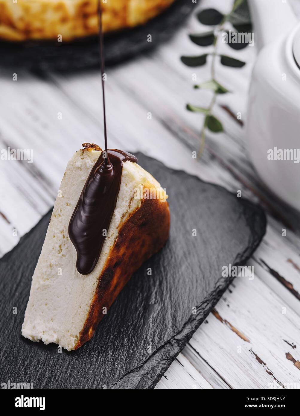 Essen, Schokolade auf den köstlichen San Sebastian Käsekuchen gießen Stockfoto