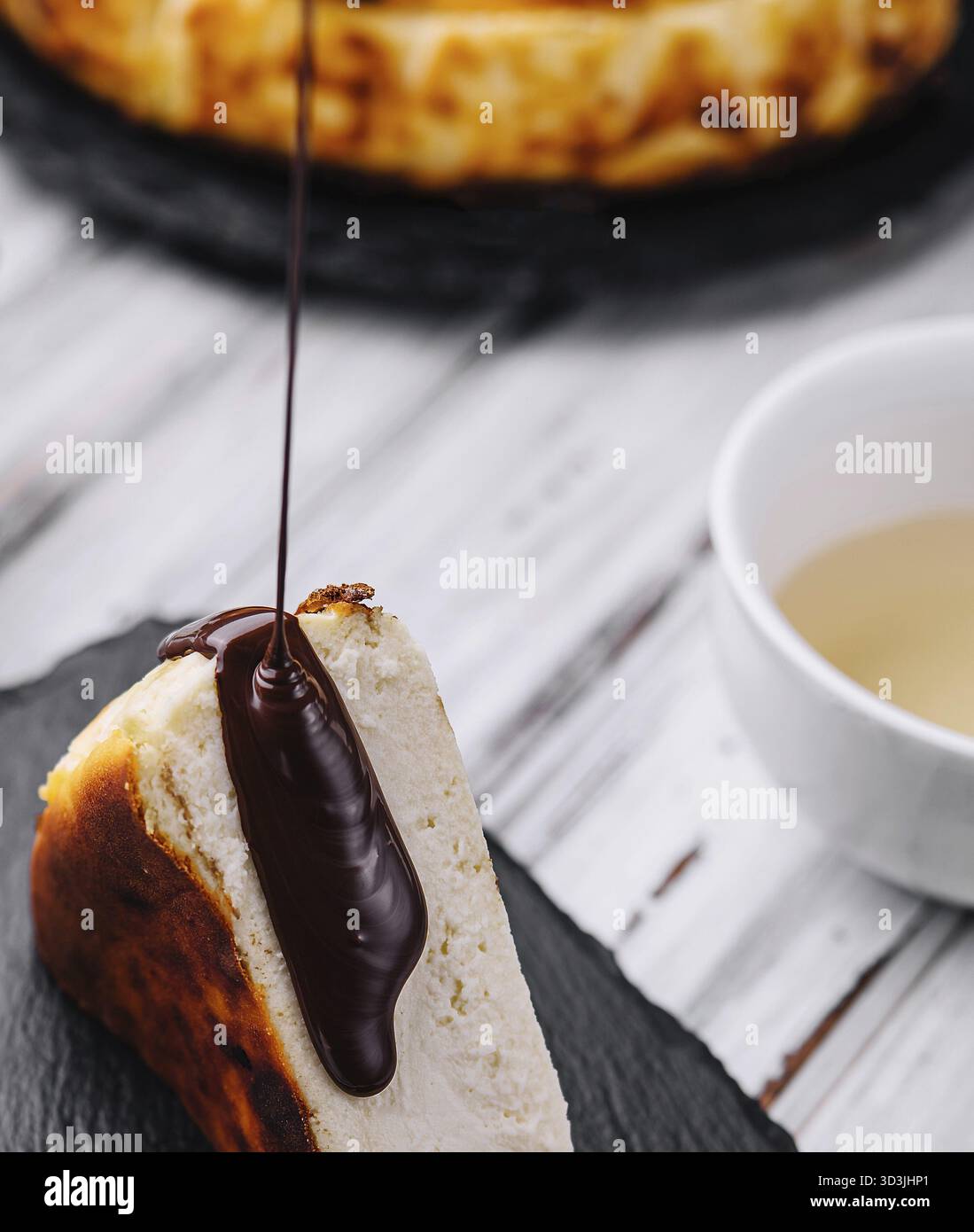 Essen, Schokolade auf den köstlichen San Sebastian Käsekuchen gießen Stockfoto