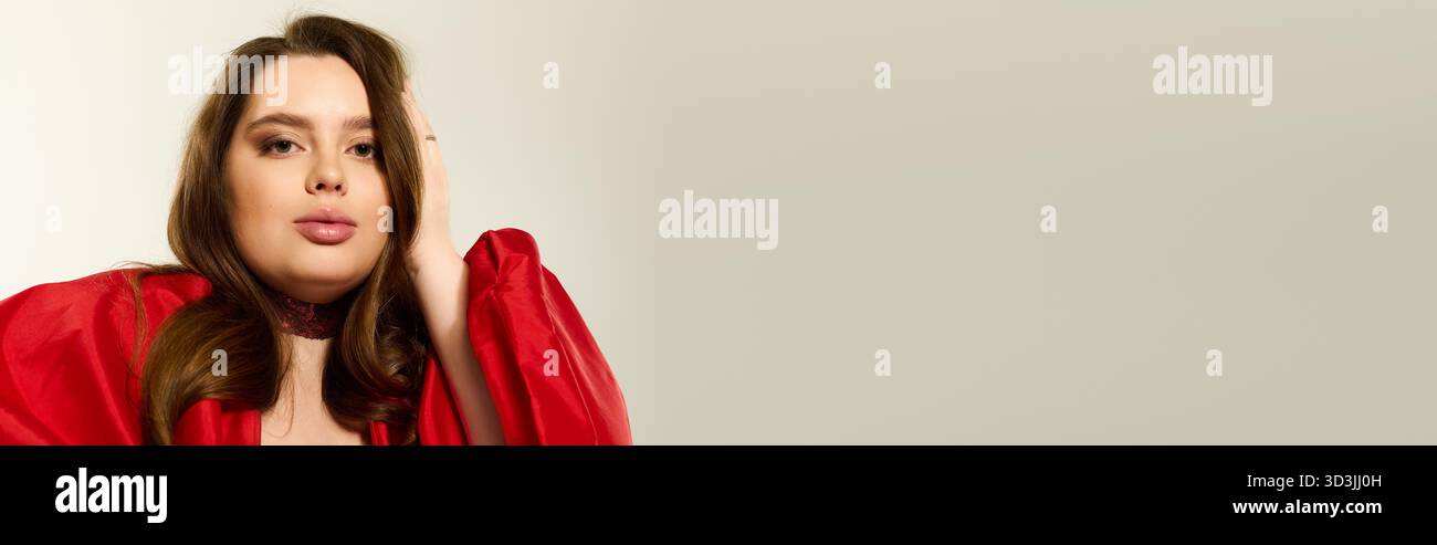 Eine große junge Frau in einem auffälligen roten Outfit, die fröhlich die Winterferien feiert, Banner Stockfoto