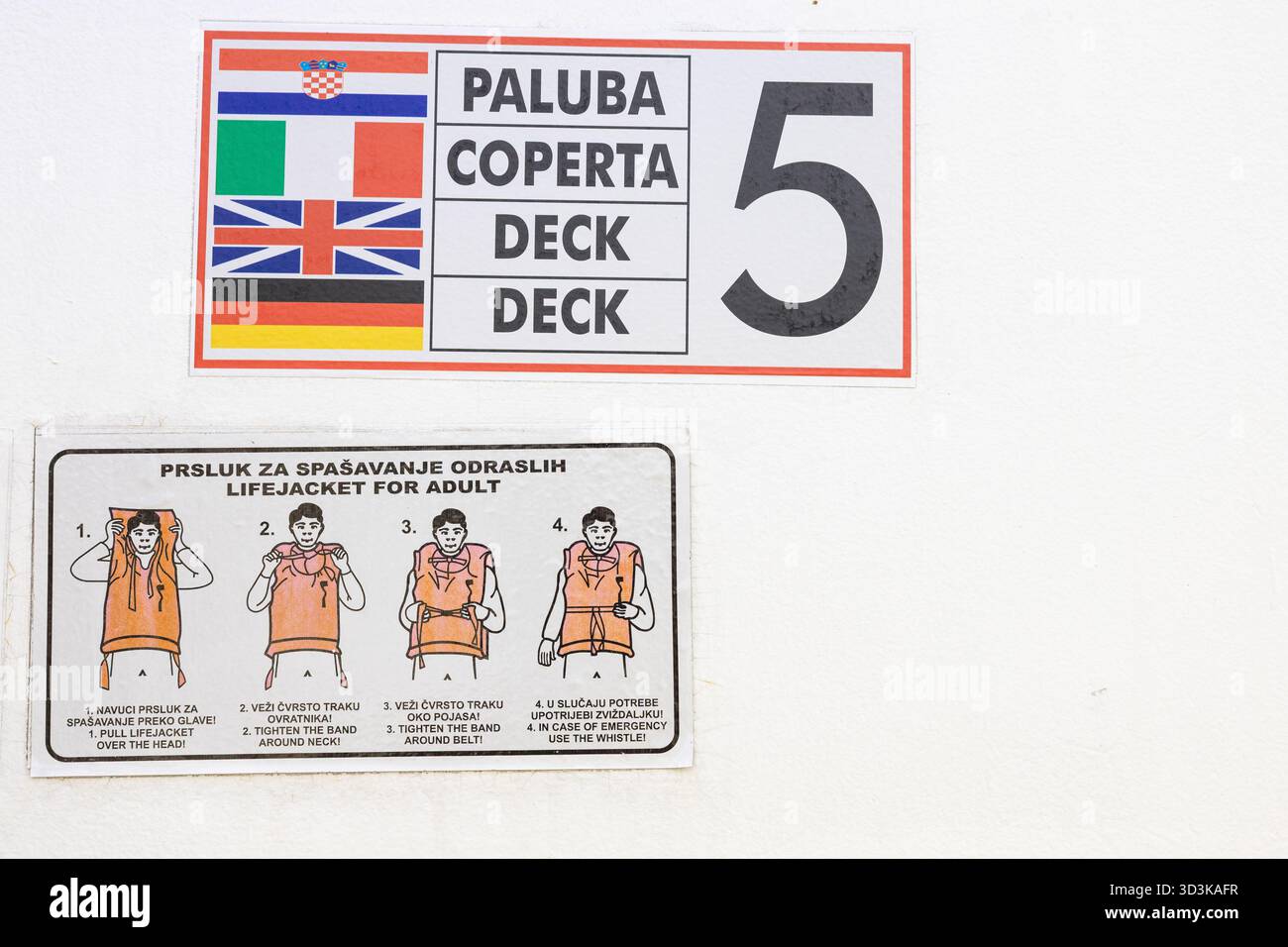 Ein breites Schild mit mehreren Nationalflaggen auf der linken Seite, ein fettgedruckter mehrsprachiger Textblock mit der Aufschrift PALUBA COPERTA DECK und eine große Zahl TW Stockfoto