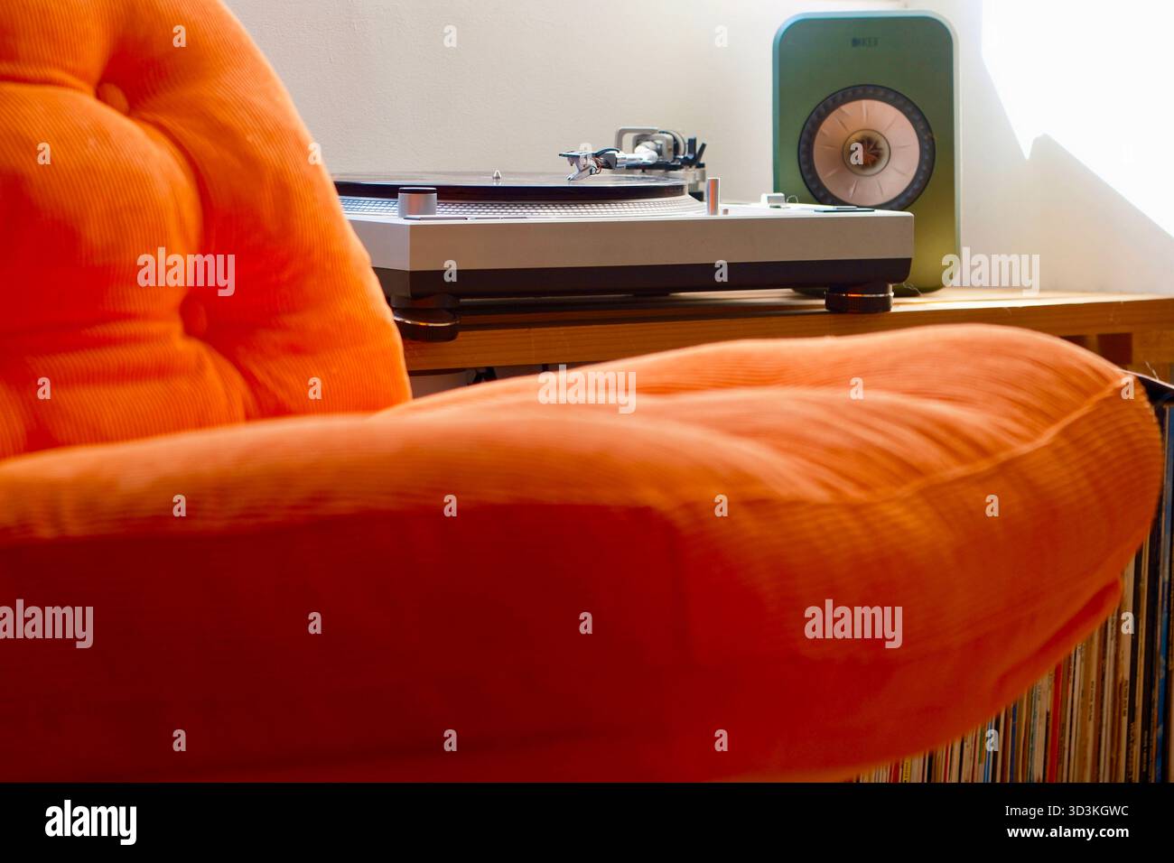 Herrlicher orangener Sessel aus den 70er Jahren mit Musik im Hintergrund. Stockfoto