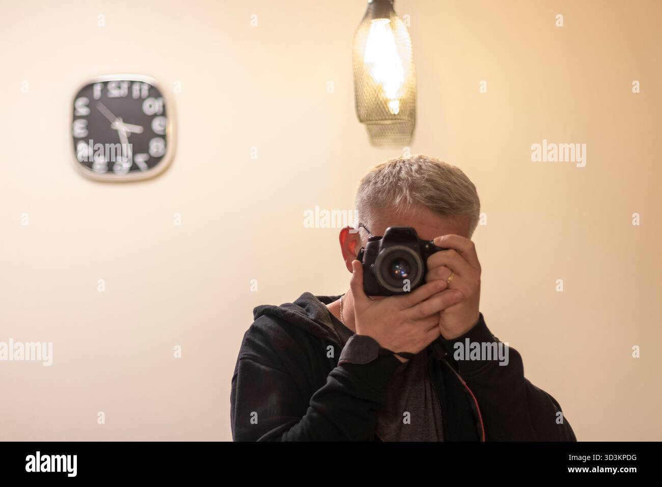 Ein Mann, der ein Selbstporträt im Spiegel mit einer Digitalkamera macht Stockfoto