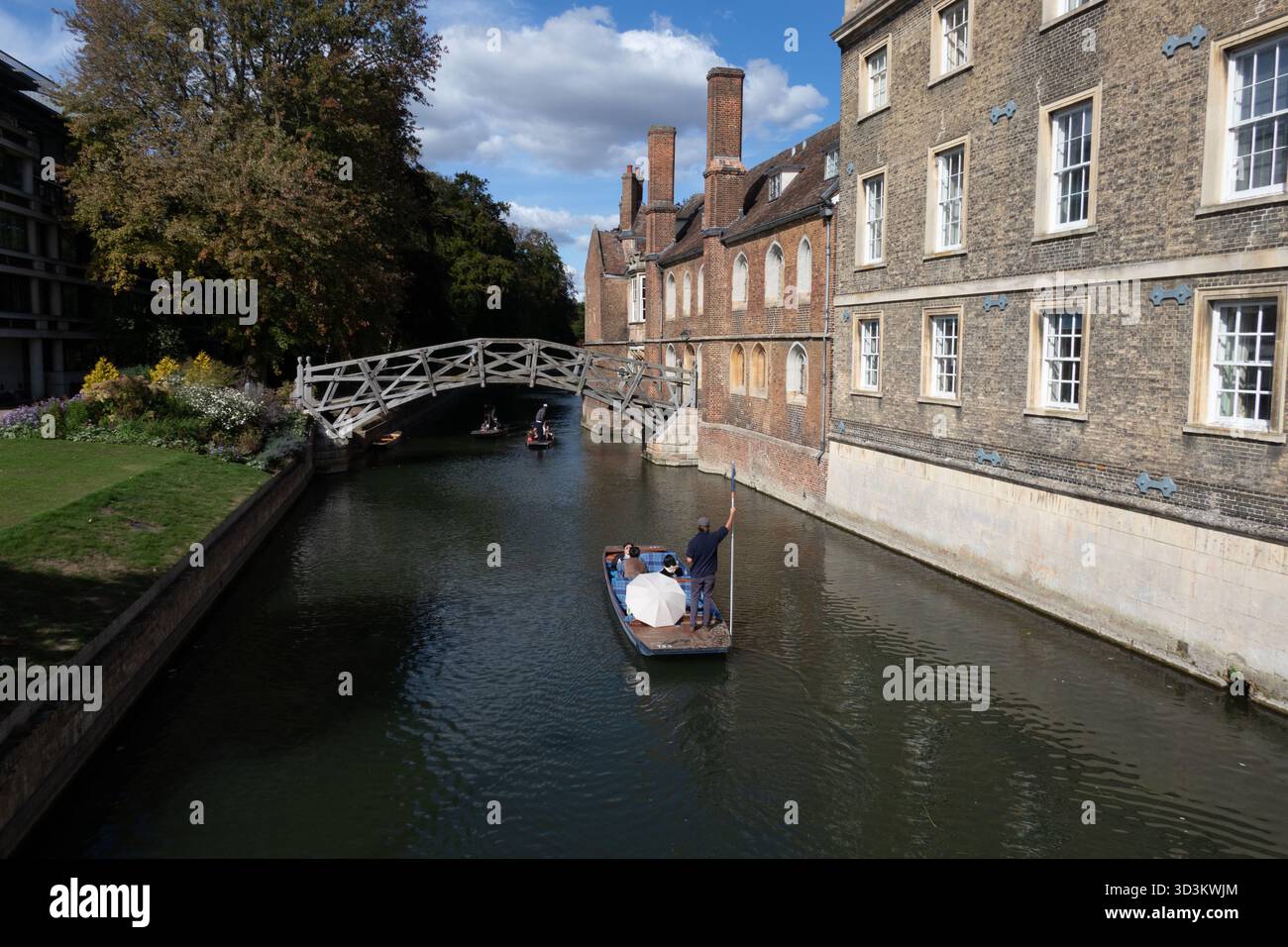 Er fährt an der Mathematical Bridge vorbei und am Queens College Cambridge England Stockfoto