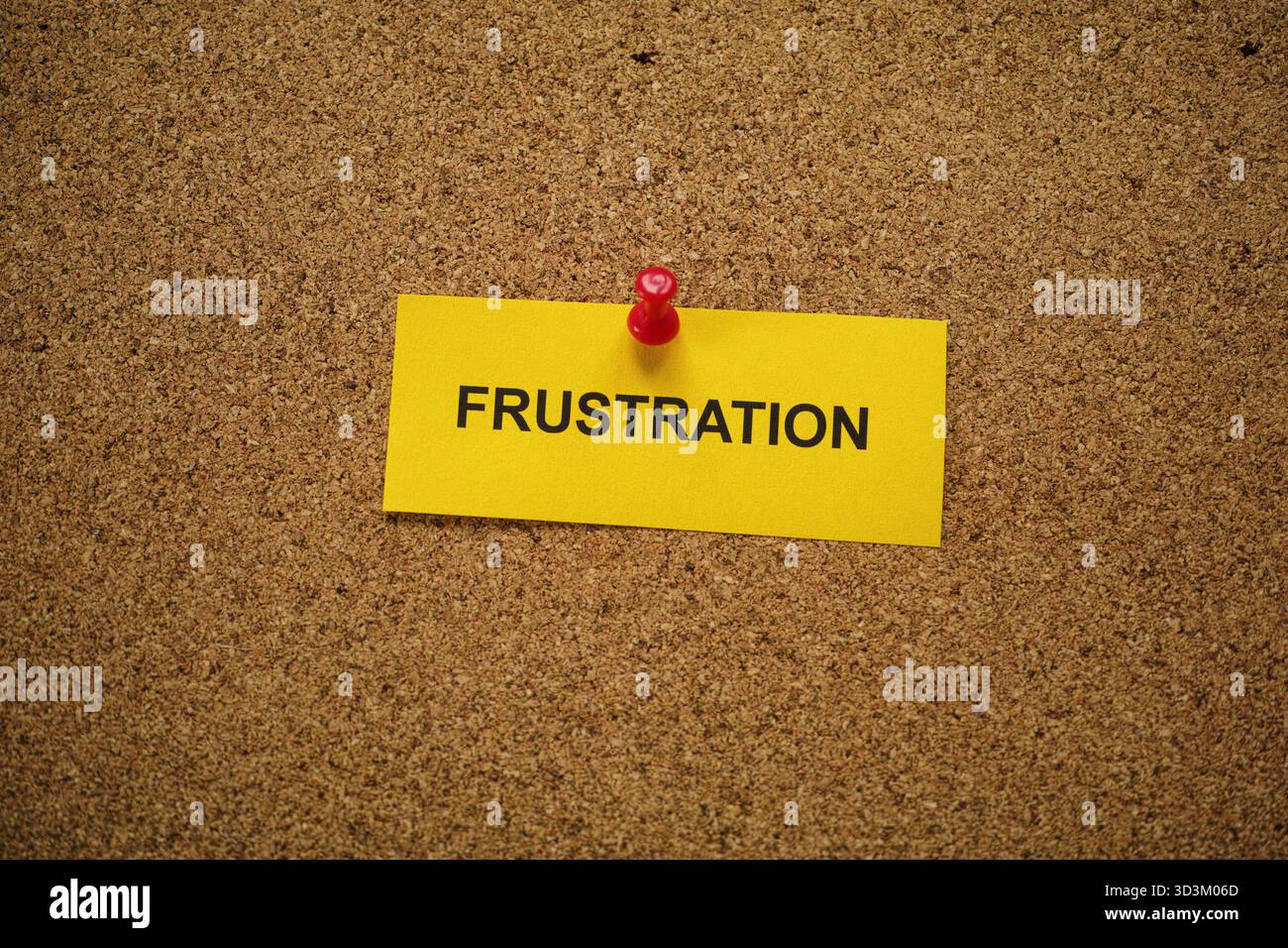Ein gelber Zettel mit dem Wort Frustration drauf, an ein Korkbrett geheftet. Nahaufnahme. Stockfoto