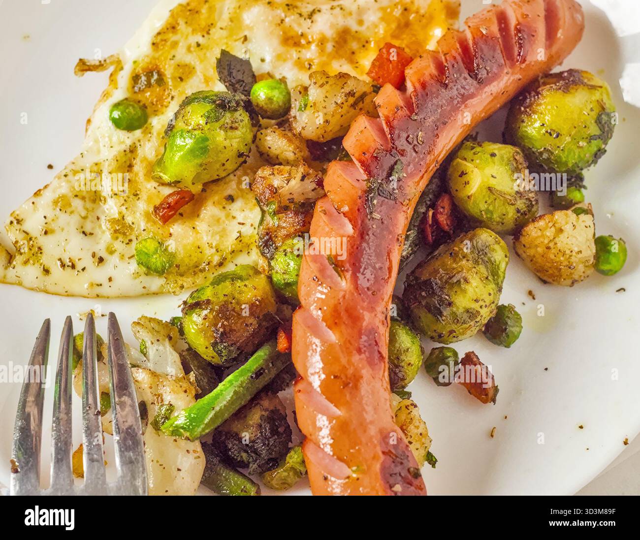 Essteller mit gebratener Wurst, Rosenkohl und Ei Stockfoto