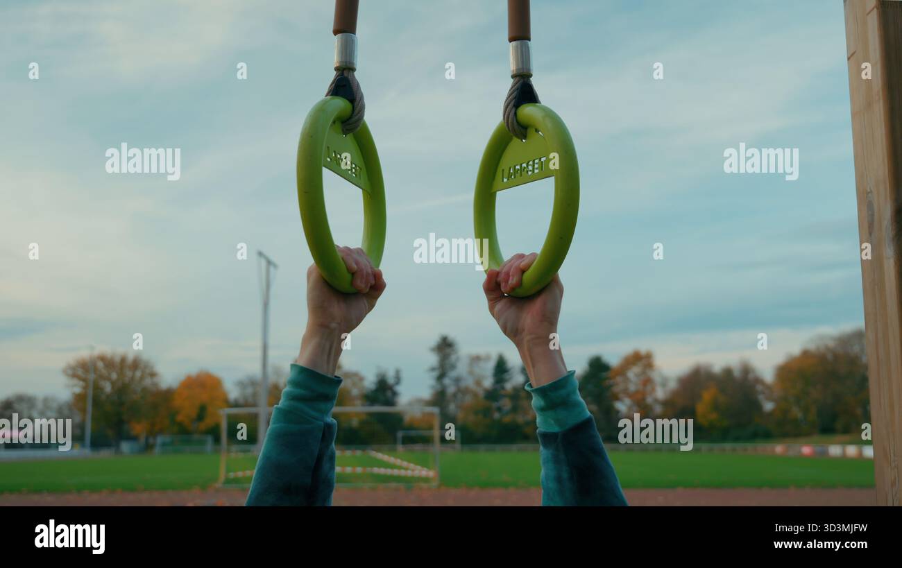 Hände halten Gymnastikringe Outdoor-Training, Fitness-Training und Krafttraining Konzept, gesunder Lebensstil und Motivation im Sportpark Stockfoto